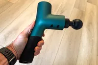 A person holds up the Ekrin B37 Massage Gun