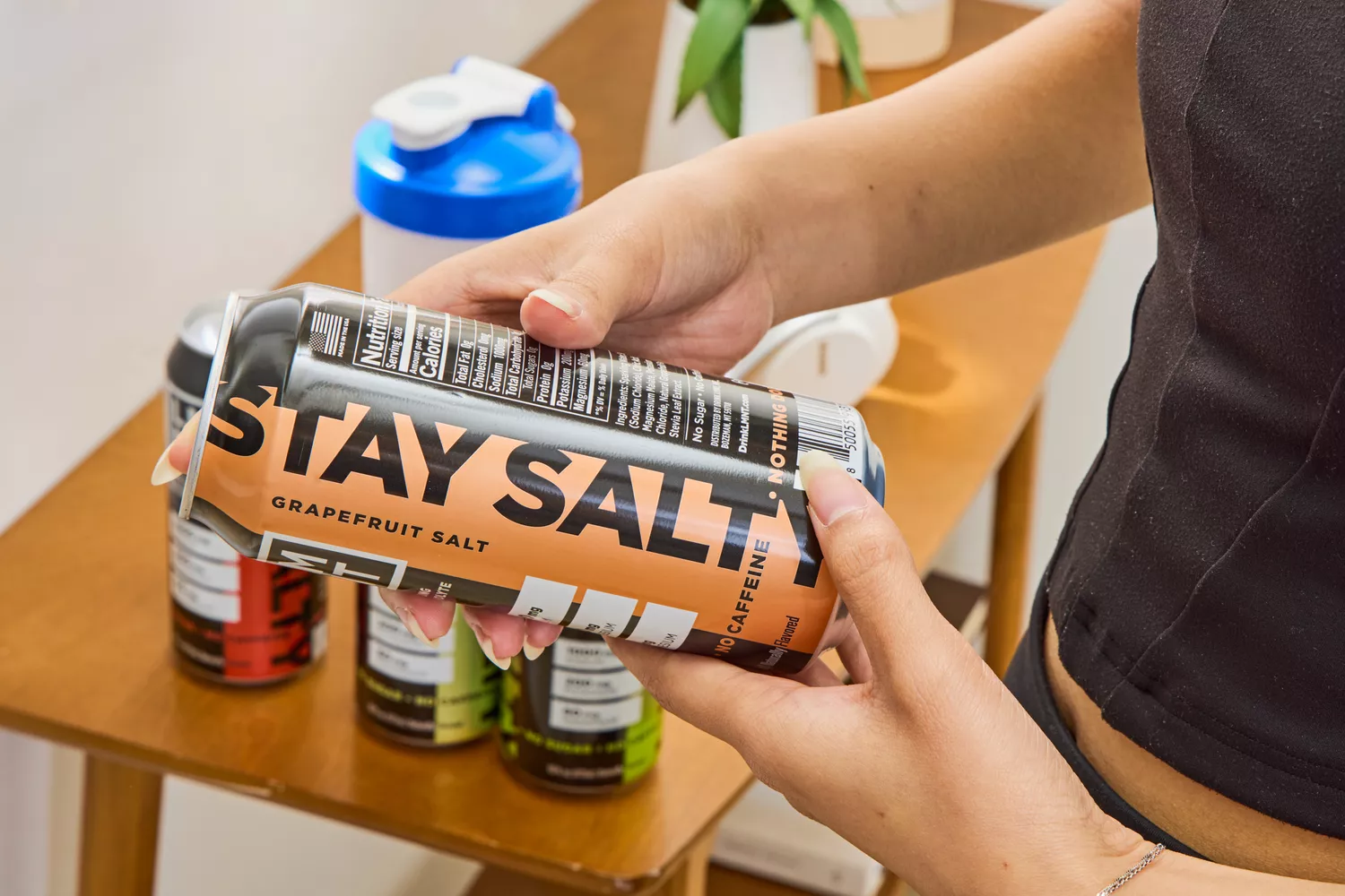 A person reads the back of a can of LMNT Sparkling Electrolyte Water
