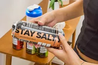 A person reads the back of a can of LMNT Sparkling Electrolyte Water