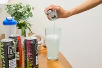 A person pours LMNT Sparkling Electrolyte Water into a glass