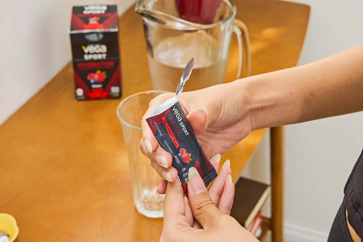 A person holds open a packet of Vega Sport Electrolyte Hydrator