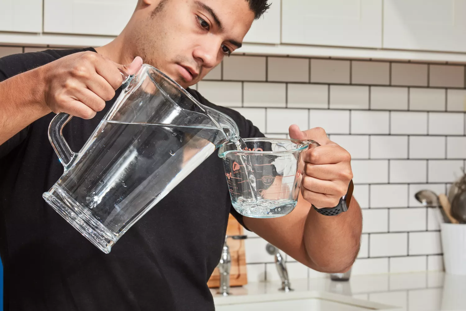 A person adding water into a measuring cup to later mix with Kaged Hydra Charge