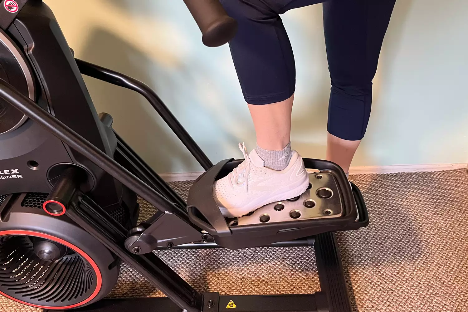 A person stepping onto the BowFlex Max Total 16