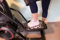 A person stepping onto the BowFlex Max Total 16
