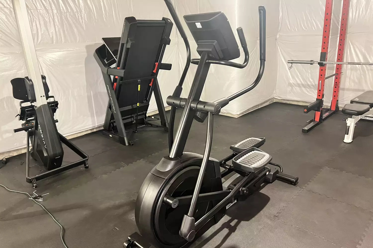 The NordicTrack AirGlide 7i Elliptical in a room filled with equiptment