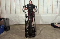 A person on the Schwinn 490 Elliptical near suitcases