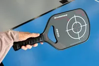 A hand holding the Engage Pickleball Aero | Raw Toray T700 in the air