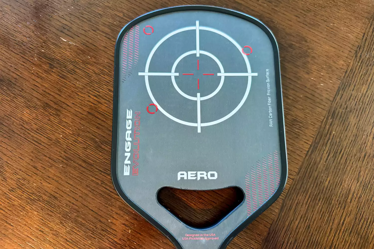 A close-up of the Engage Pickleball Aero | Raw Toray T700 on a wooden surface