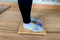 A side view of a person standing on the Escali Bamboo Digital Electronic Bathroom Scale