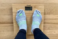 A person stands on the Escali Bamboo Digital Electronic Bathroom Scale
