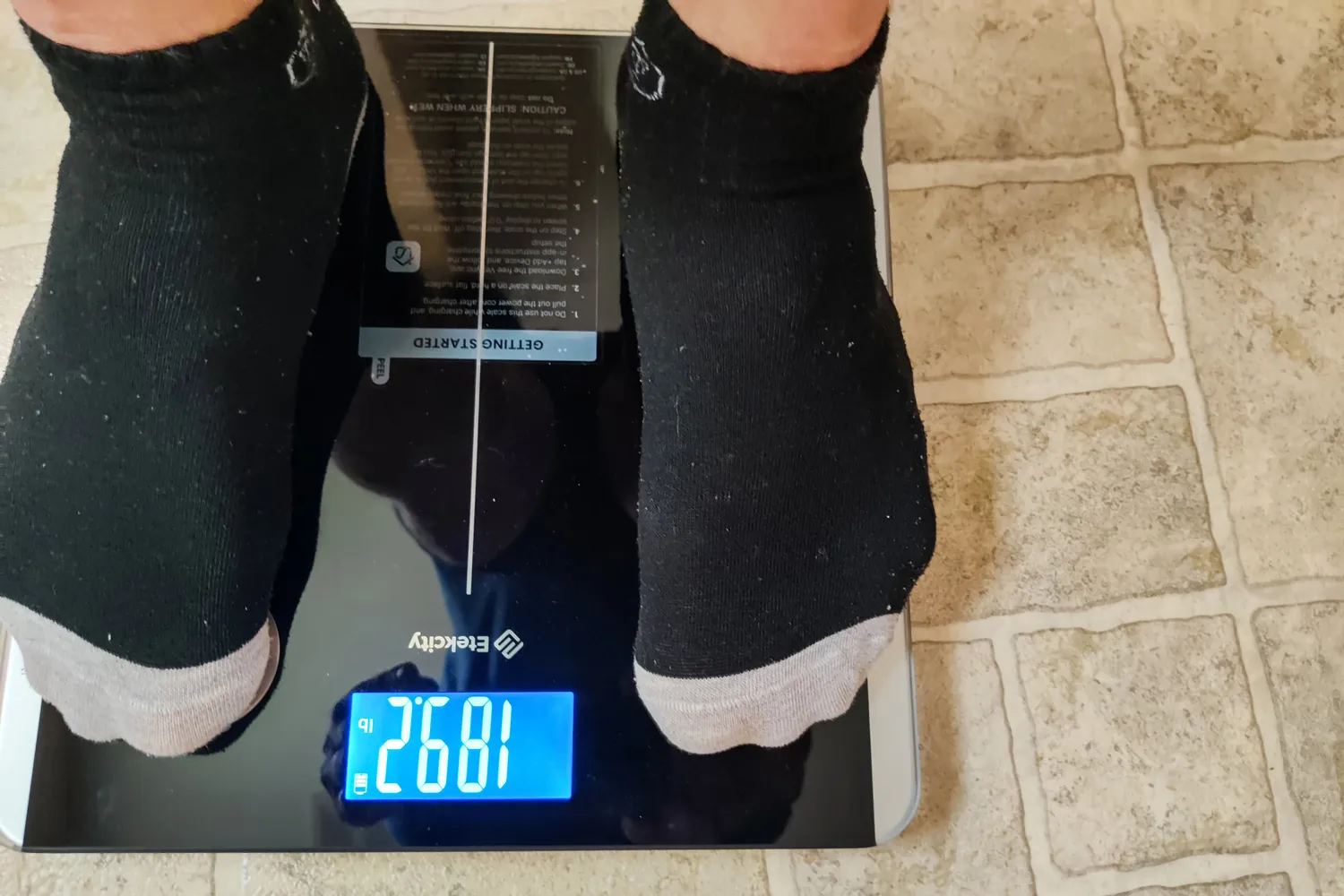 A person stands on the Etekcity ESF93 Smart Fitness Scale