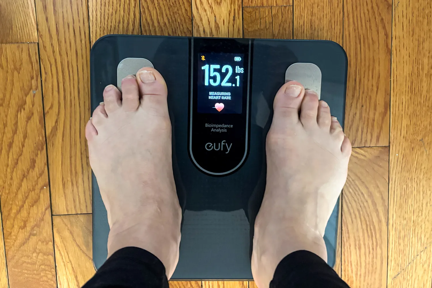A person stands barefoot on the eufy Smart Scale C20