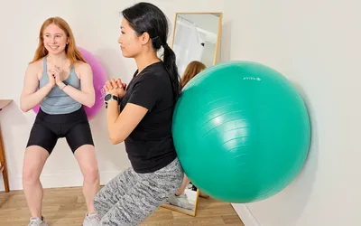 A person exercises using the Gaiam Total Body Balance Ball Kit