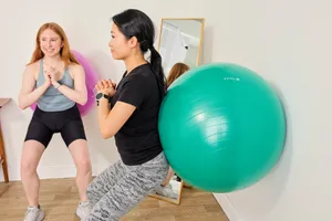A person exercises using the Gaiam Total Body Balance Ball Kit