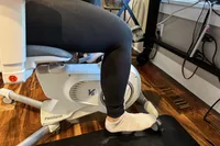 A close-up of a person's legs pedaling on the Flexispot Deskbike V6 Pro