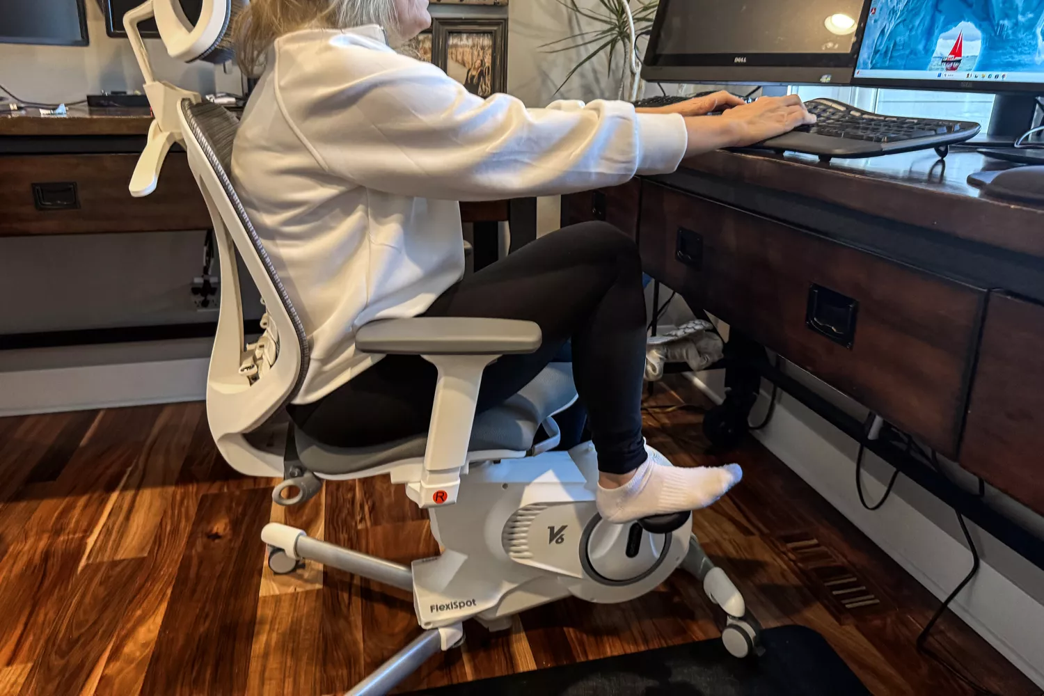 A person using the Flexispot Deskbike V6 Pro while typing on a keyboard