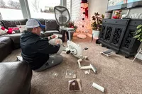 A person sitting on a carpet while assembling the Flexispot Deskbike V6 Pro