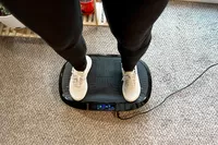 An overhead view of a person standing on the Flybird Mini Vibration Plate