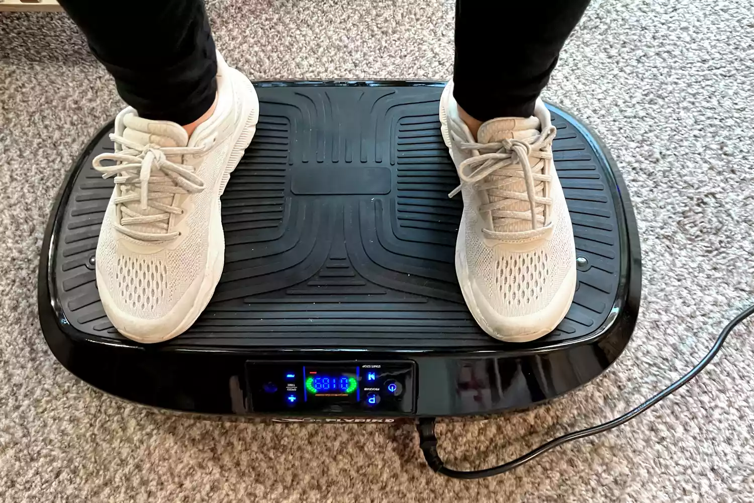 A person stands on the Flybird Mini Vibration Plate