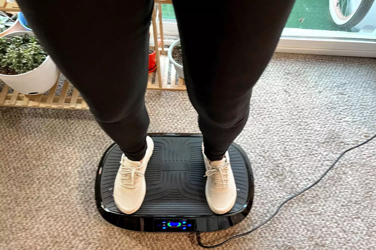 A person stands on the Flybird Mini Vibration Plate in sneakers