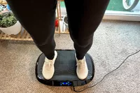 A person stands on the Flybird Mini Vibration Plate in sneakers