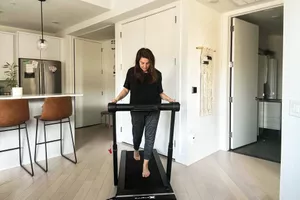 A person walking on the XTerra WS200 WalkSlim Treadmill near their kitchen