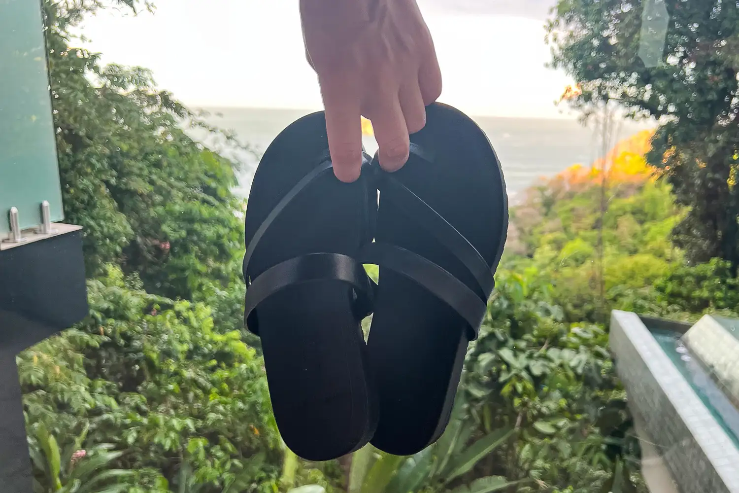 A person holds the Frankie4 Women's Isla Slides by the straps