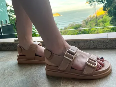 A person wears the Frankie4 Thompson Sandals while walking on tile