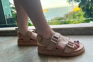 A person wears the Frankie4 Thompson Sandals while walking on tile