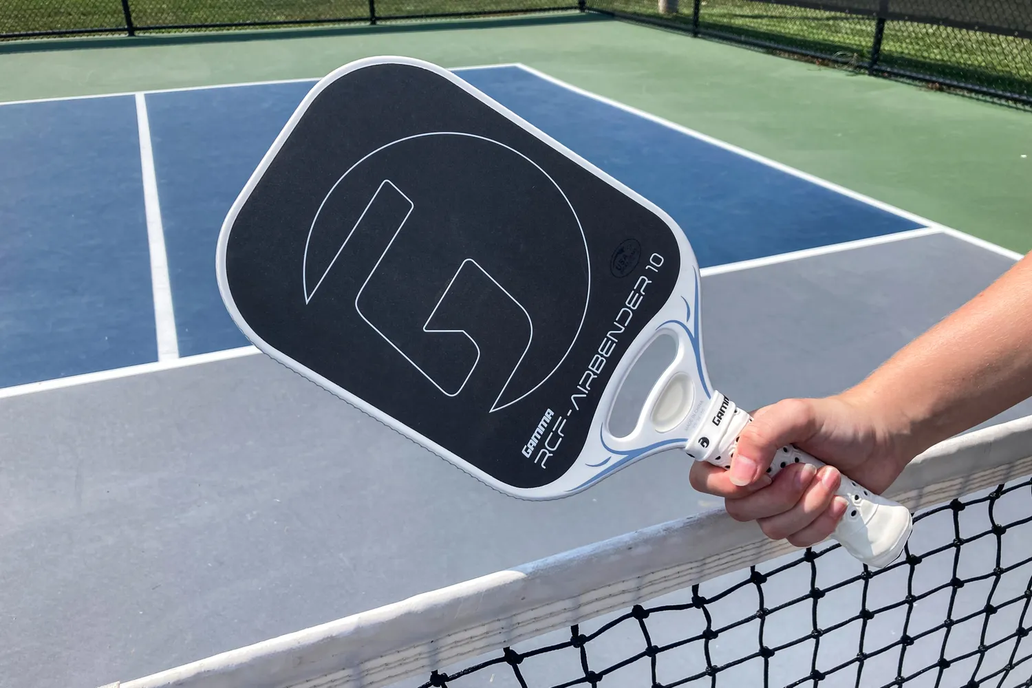 A person holds up the GAMMA Airbender 10 Pickleball Paddle
