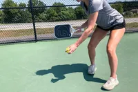 A person serves using the GAMMA Airbender 10 Pickleball Paddle