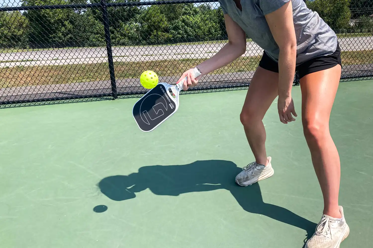 A person hits a pickleball using the GAMMA Airbender 10 Pickleball Paddle