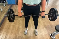 A person lifts weights while wearing the Garmin vívosmart 5 Fitness Tracker