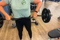 A person lifts weights while wearing the Garmin Vivosmart 5 Fitness Tracker.