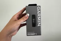 A person holds up the box for the Garmin vívosmart 5 Fitness Tracker