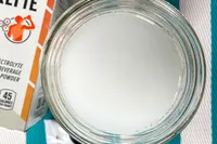 A jar containing a clear liquid next to an electrolyte powder package