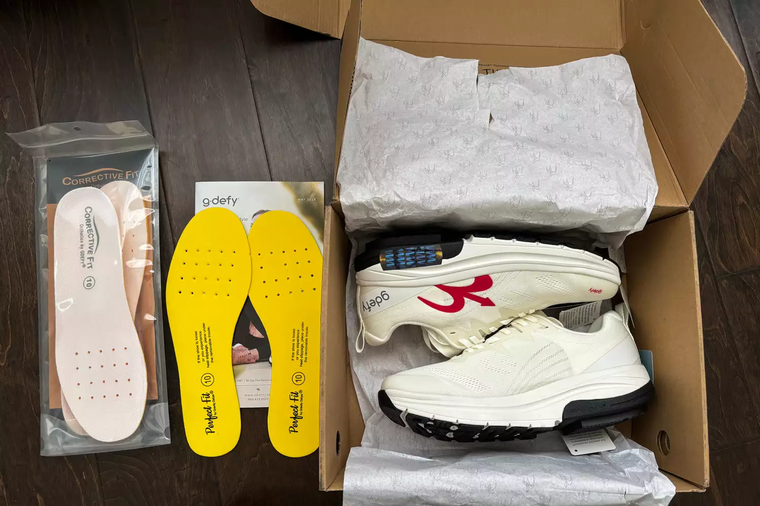 The GDEFY Men's Lauff Athletic Shoes in the box beside insoles