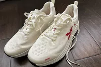 A pair of GDEFY Men's Lauff Athletic Shoes with the laces untied