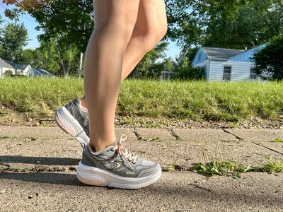 A person walks outside while wearing the GDEFY Women's Ion Athletic Shoes