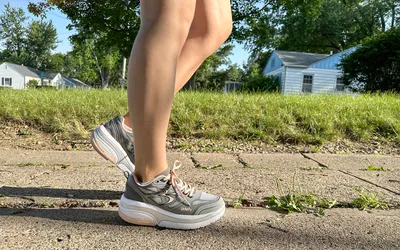A person walks outside while wearing the GDEFY Women's Ion Athletic Shoes