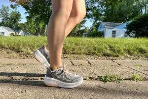 A person walks outside while wearing the GDEFY Women's Ion Athletic Shoes