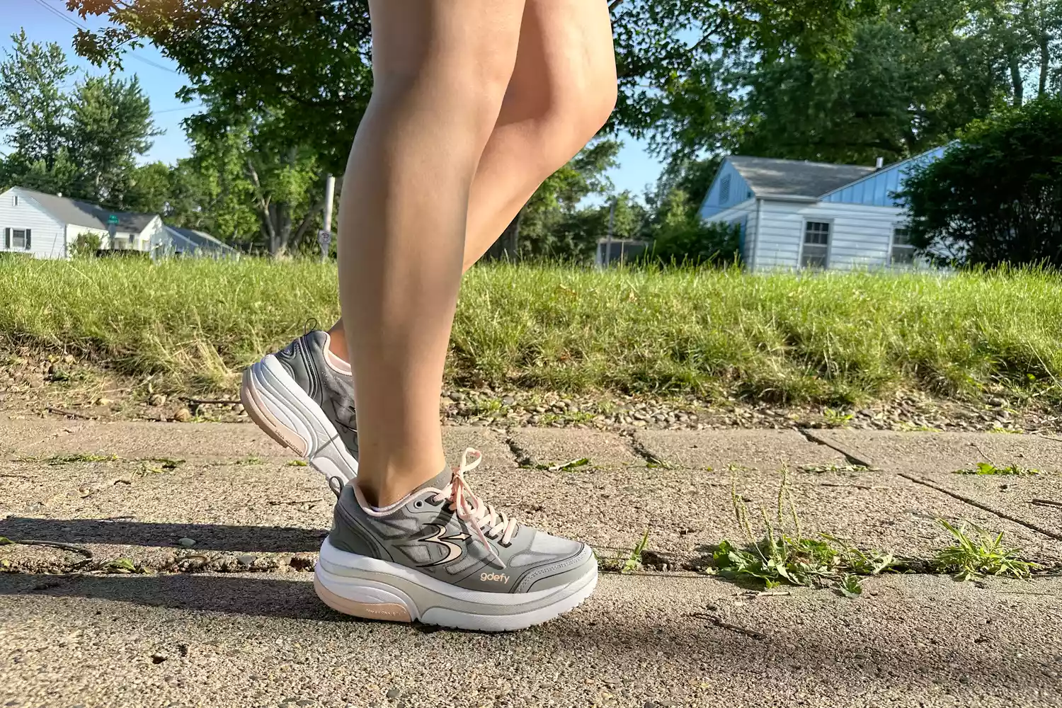 A person walks outside while wearing the GDEFY Women's Ion Athletic Shoes