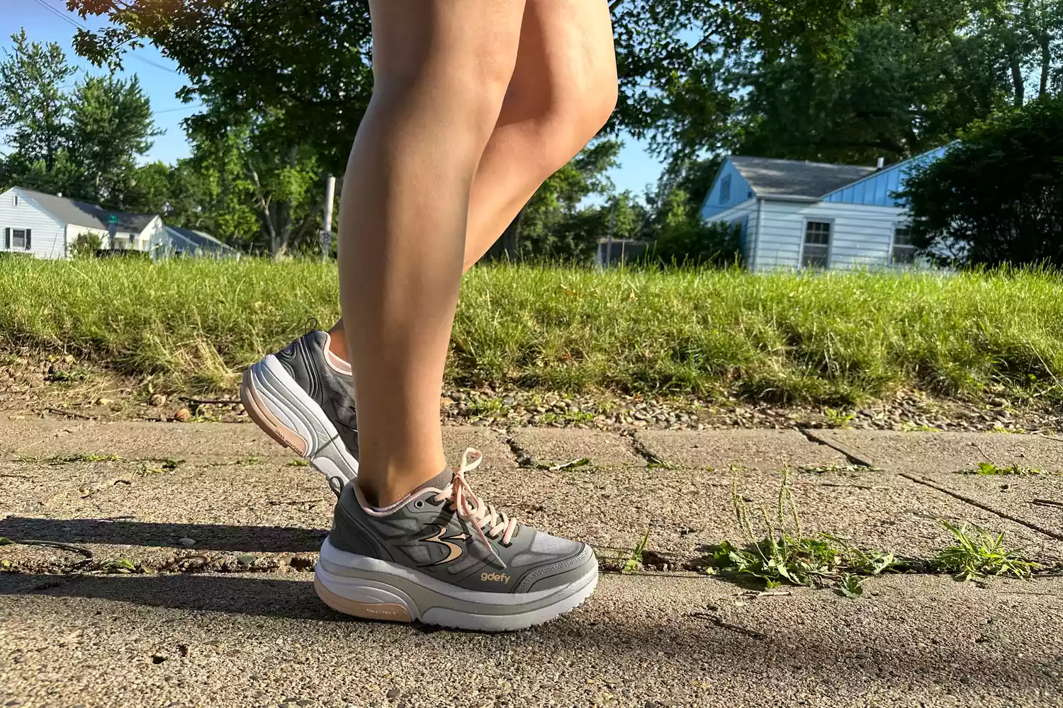 A person walks outside while wearing the GDEFY Women's Ion Athletic Shoes