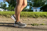 A person walks outside while wearing the GDEFY Women's Ion Athletic Shoes