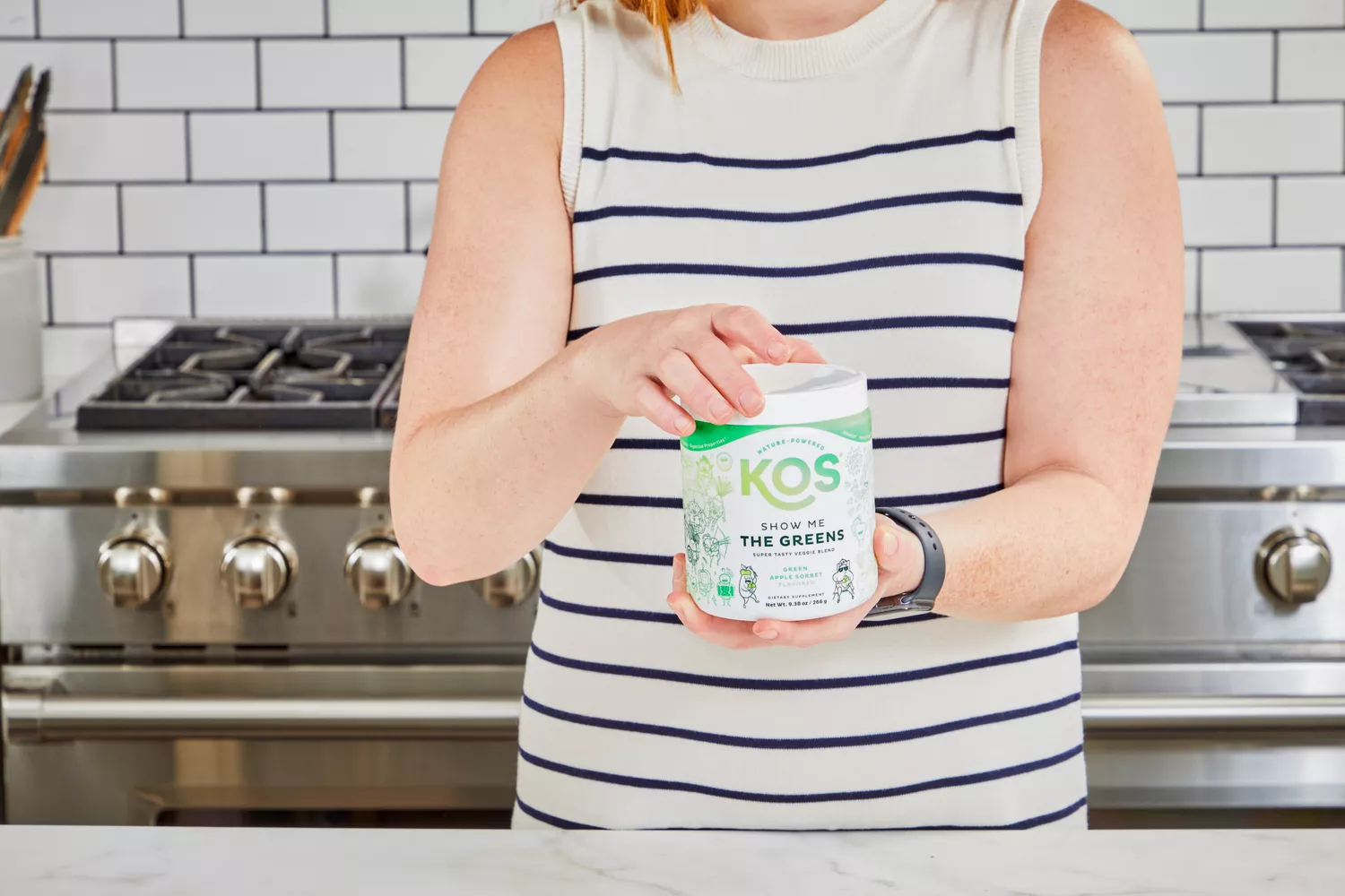 Person holding KOS Show Me the Greens Powder