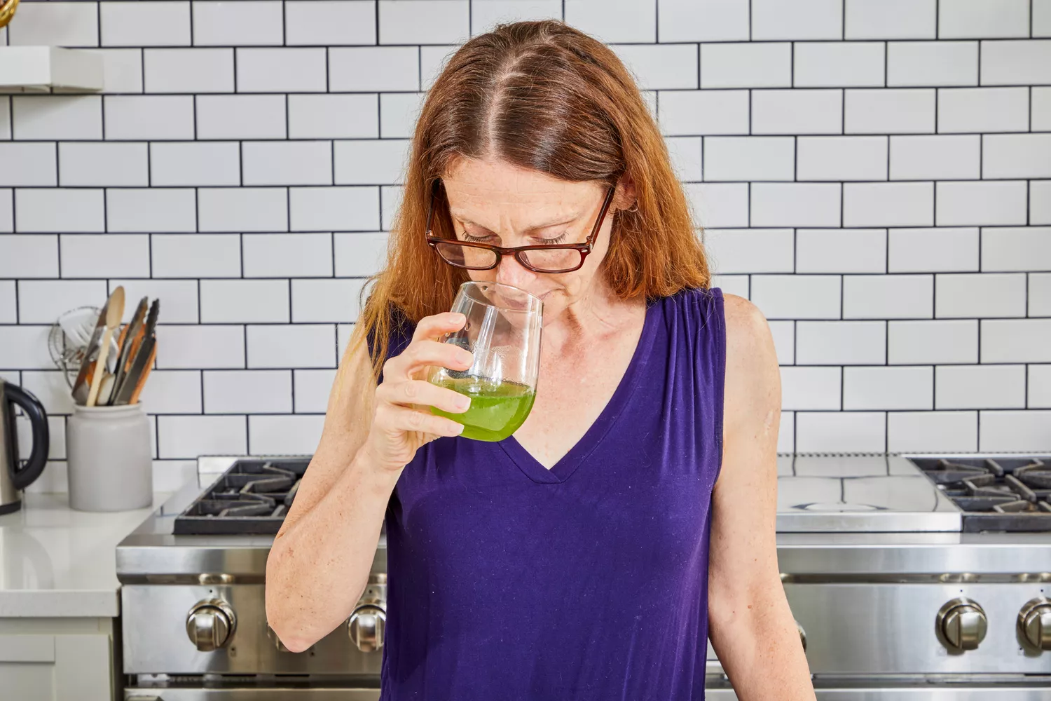 Person smelling True Grace Superfood Powder Broccoli Microgreens from glass