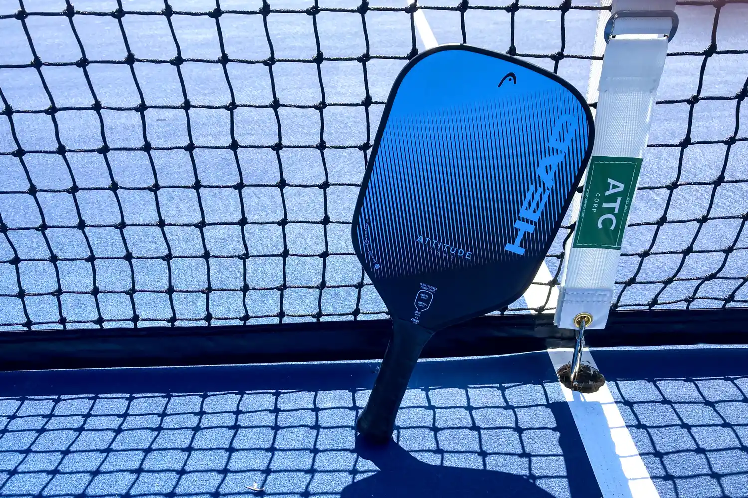 The HEAD Attitude Core Pickleball Paddle rests on a net