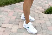 A person walks outside on brick while wearing the HEAD Women's Revolt Pro 4.5 Pickleball Shoes