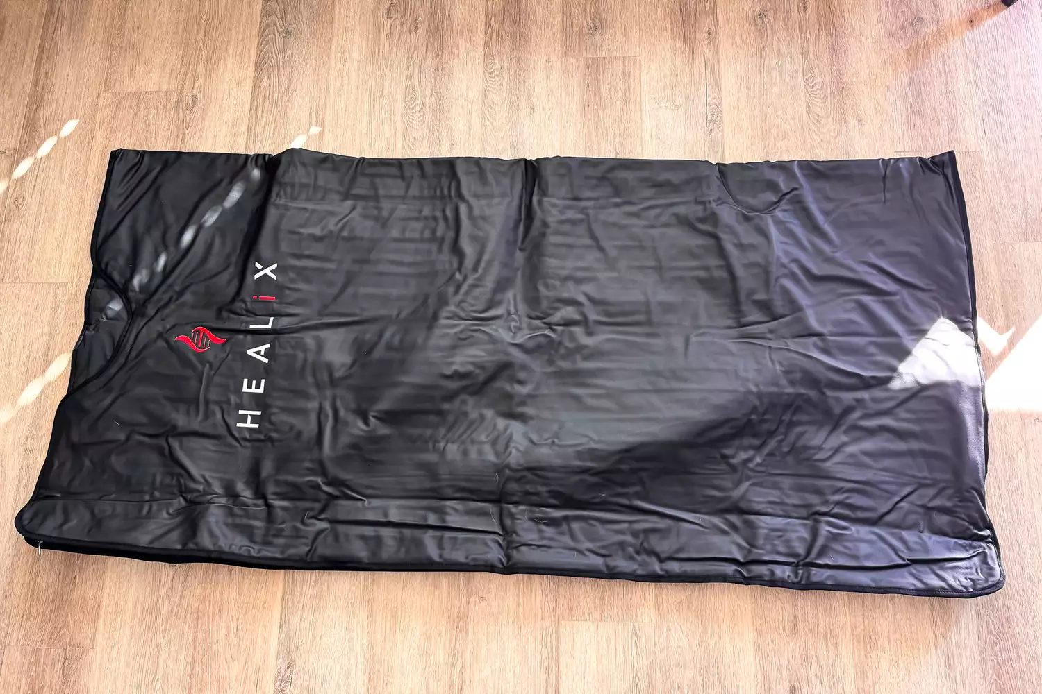 The HEALiX-Z Sauna Blanket on a wooden floor