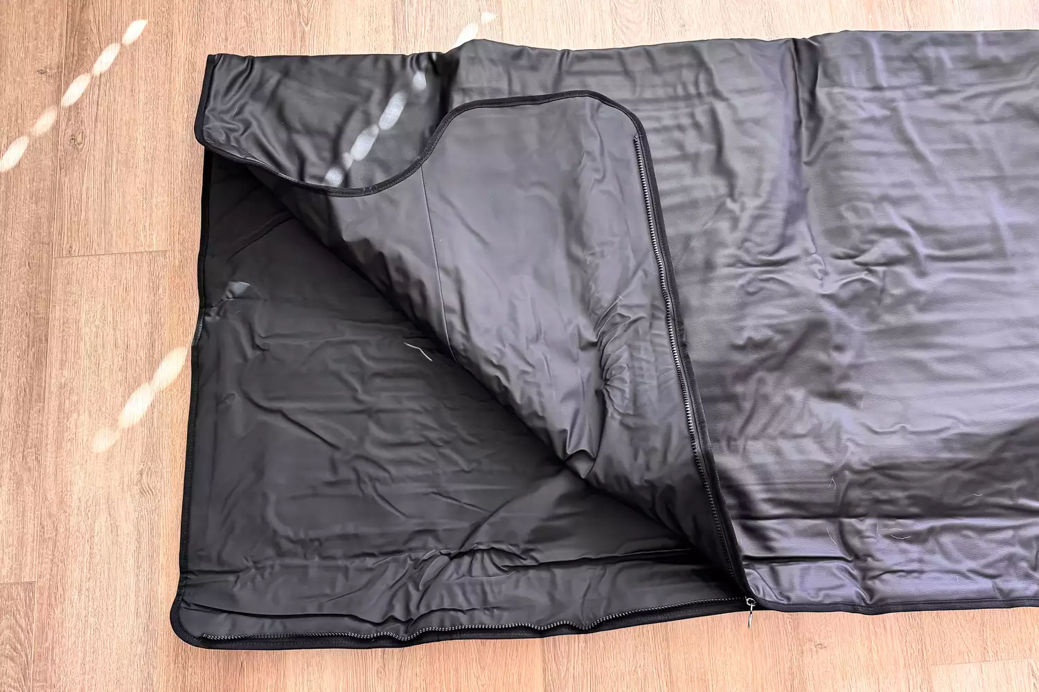 The HEALiX-Z Sauna Blanket on a wooden floor